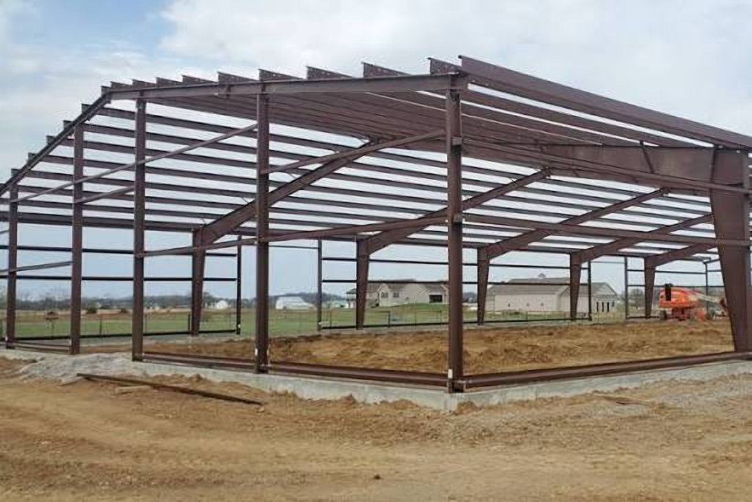 Brown structural steel building frame on a concrete foundation