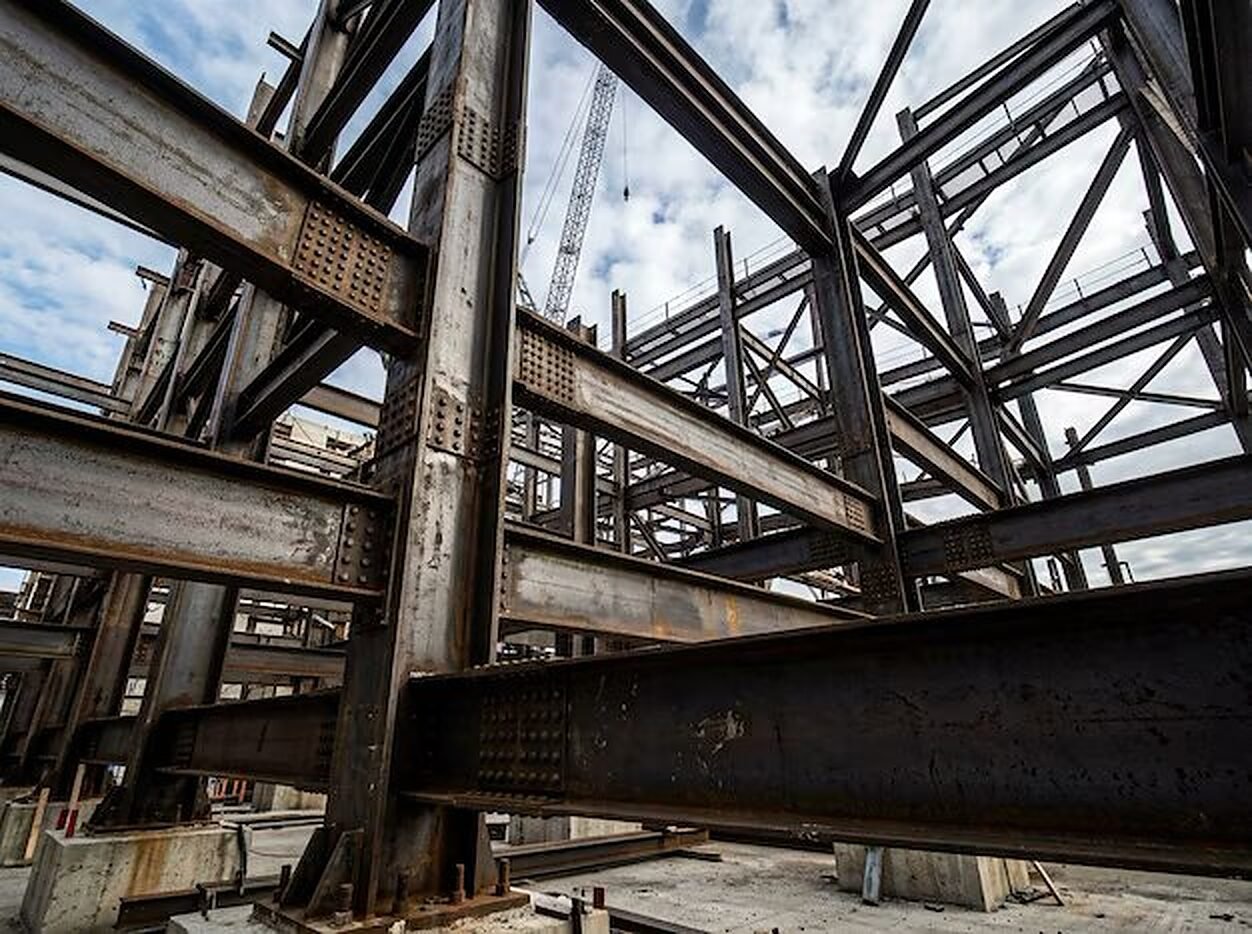 Structural steel frame rising toward a tower crane